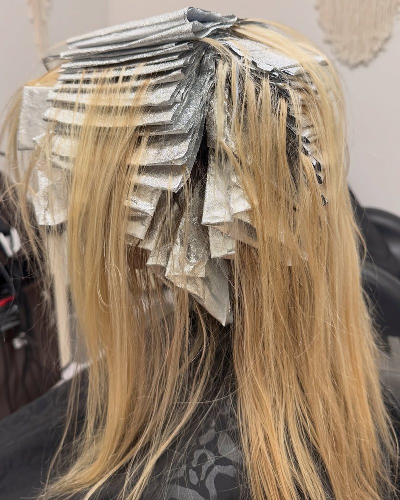 Packed-in foils processing on long blonde hair — partial foil in progress by a blonding specialist in the Sacramento area.