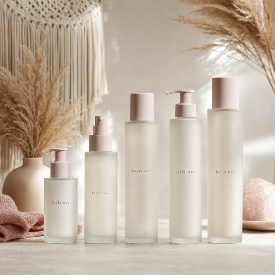 The Kayla Mac color-safe haircare lineup — shampoo, oils, and treatments lined up on a shelf.